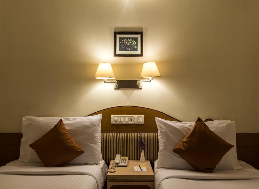 Postel nebo postele na pokoji v ubytování Hotel Park Central Koregaon Park