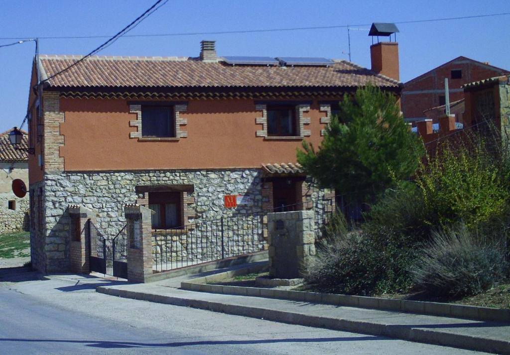 una vecchia casa in pietra sul lato di una strada di Apartamentos turísticos La Fuensanta a Cella