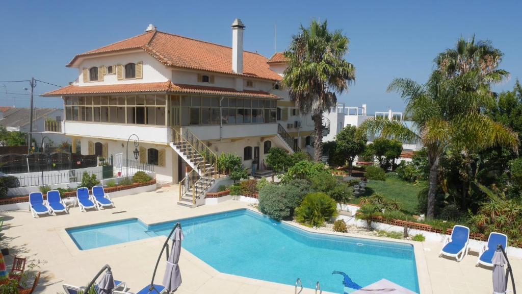 une grande maison avec une piscine en face de celle-ci dans l'établissement Casa Deixa-O-Resto Guesthouse, à Santo André