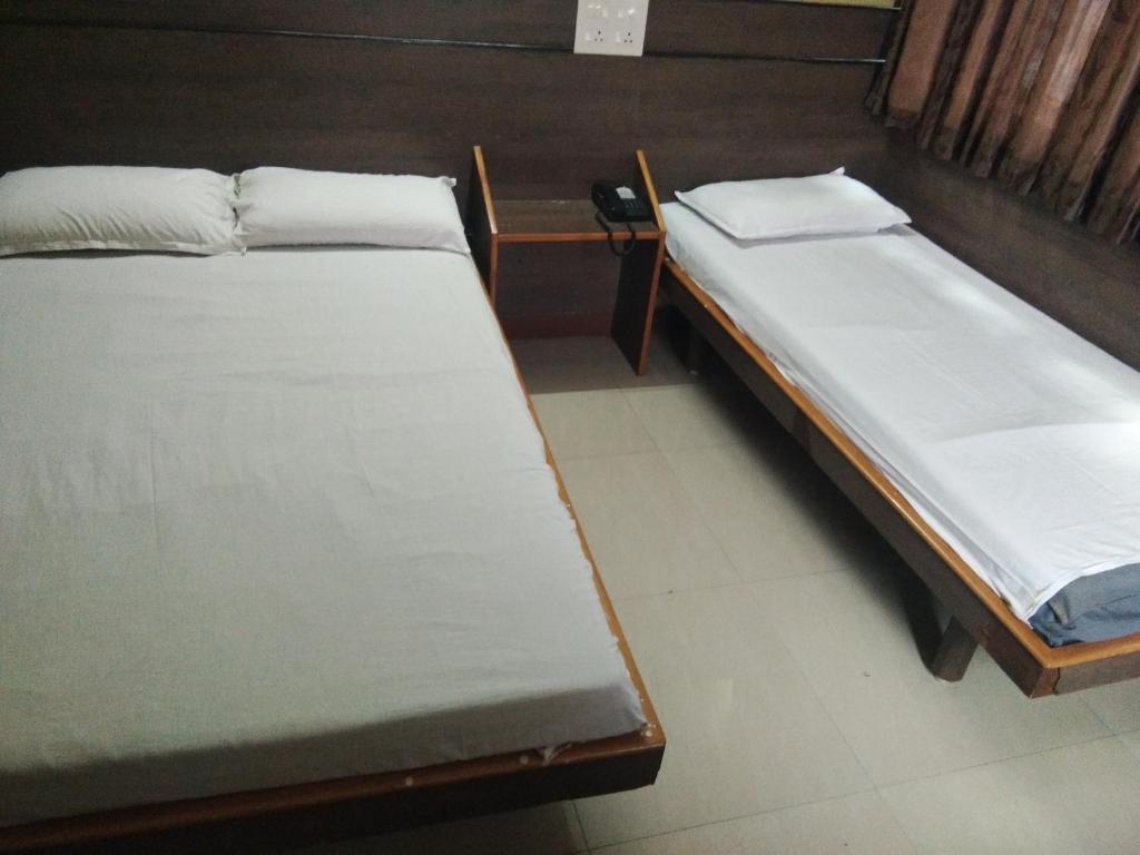 Zwei Betten befinden sich in einem Zimmer in der Unterkunft Sri Saraswathi Lodge in Tiruchchirāppalli