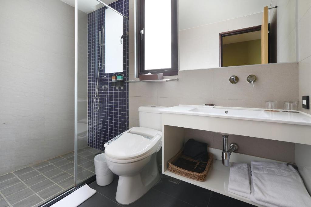 a bathroom with a toilet and a sink and a shower at KUN Hotel in Taichung