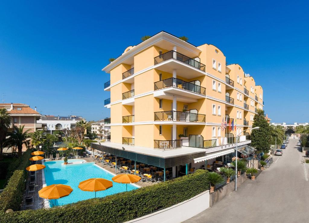 un hotel con piscina y sombrillas de color naranja en Hotel Imperial, en San Benedetto del Tronto