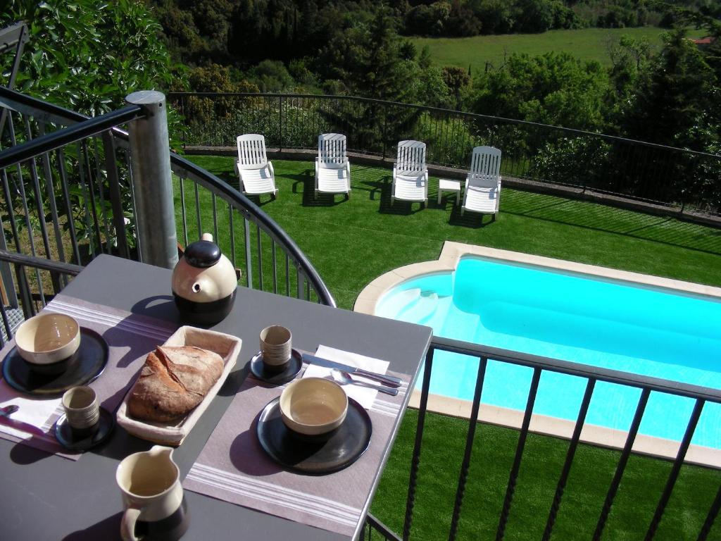 una mesa con un plato de comida junto a una piscina en Écurie De Cucugnan en Cucugnan