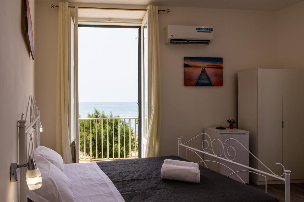 a bedroom with a bed and a large window at Sea Beach Pozzallo in Pozzallo