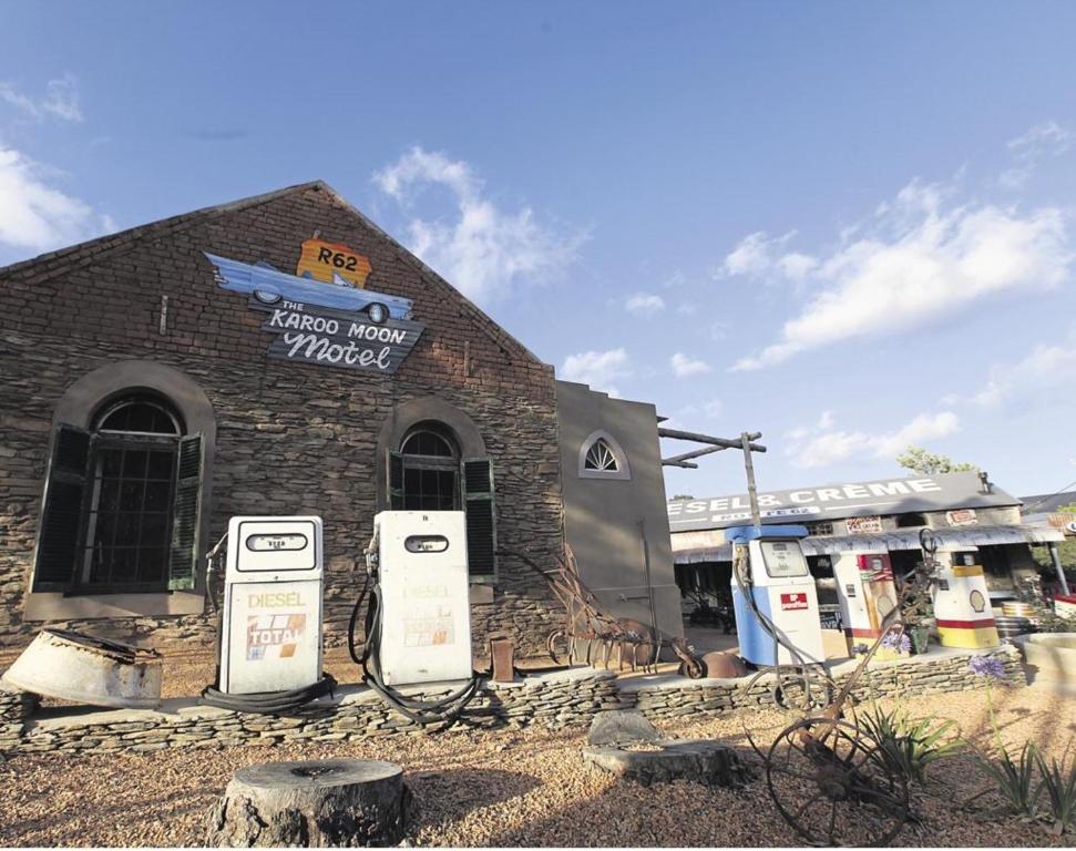 un edificio de ladrillo con dos bombas de gas delante en The Karoo Moon Motel, en Barrydale