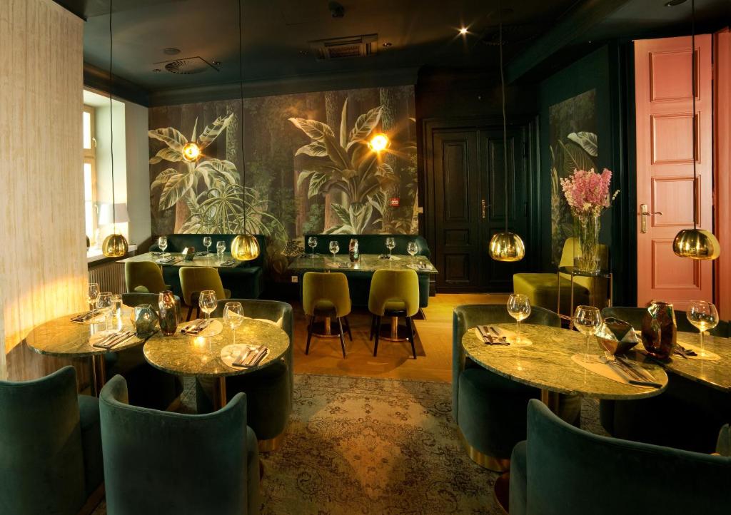a restaurant with tables and chairs and a wall with plants at H15 Boutique Hotel, Warsaw, a Member of Design Hotels in Warsaw