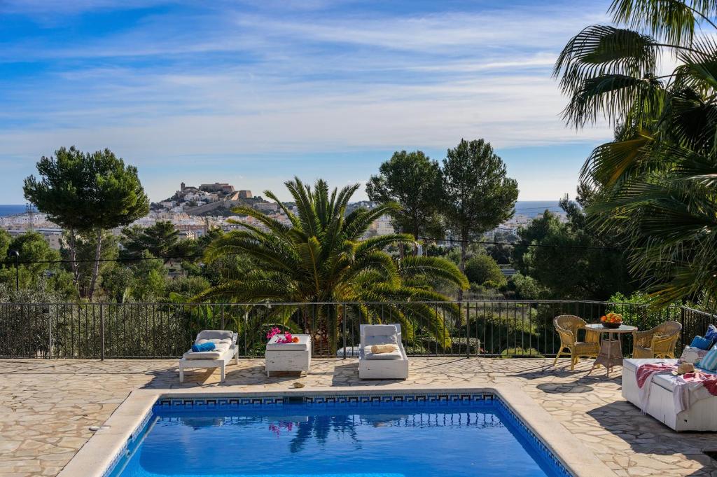 una piscina con sedie e vista sulla città di Can Pep a Ibiza Città