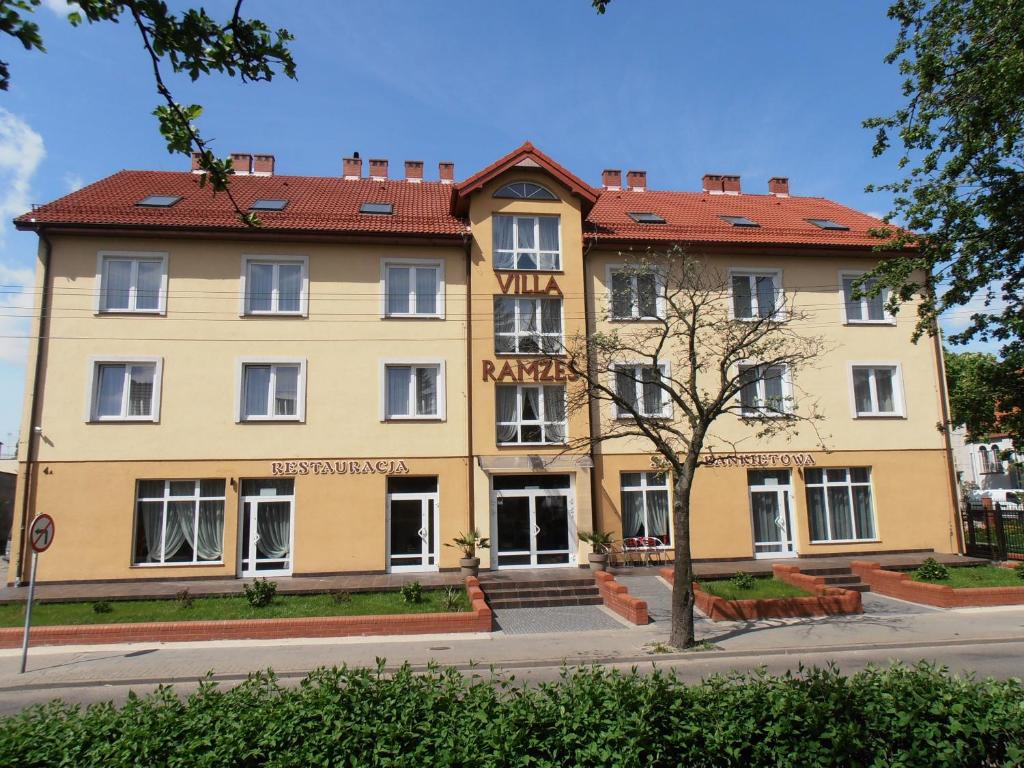 a large yellow building with a red roof at Villa Ramzes in Gdańsk