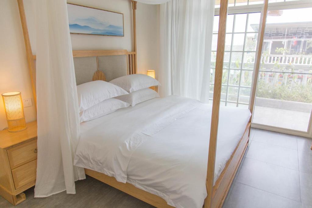 1 dormitorio con 1 cama con sábanas blancas y ventana en Bloom Time Guest House, en Dujiangyan