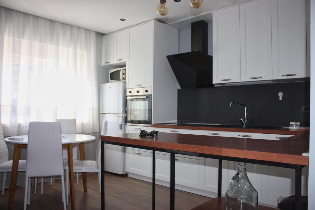 a kitchen with white cabinets and a table with chairs at Apt 16-Tirana Very Central Apartment in Tirana