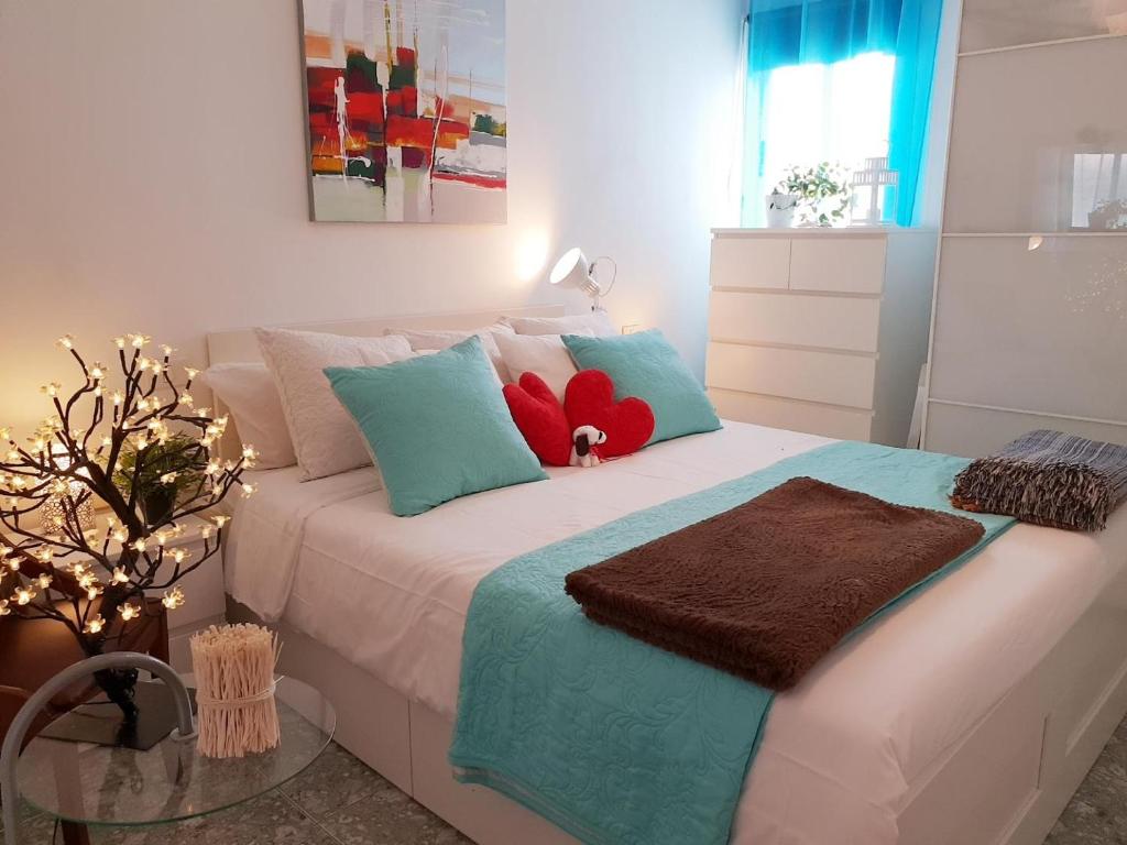 een slaapkamer met een bed met blauwe en rode kussens bij Gran canaria (arinaga) in Arinaga