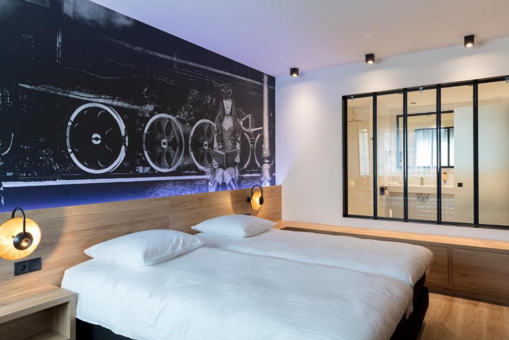 1 dormitorio con 1 cama y una gran pintura en la pared en Hotel Leo Station, Villa et Annexes en Bastogne