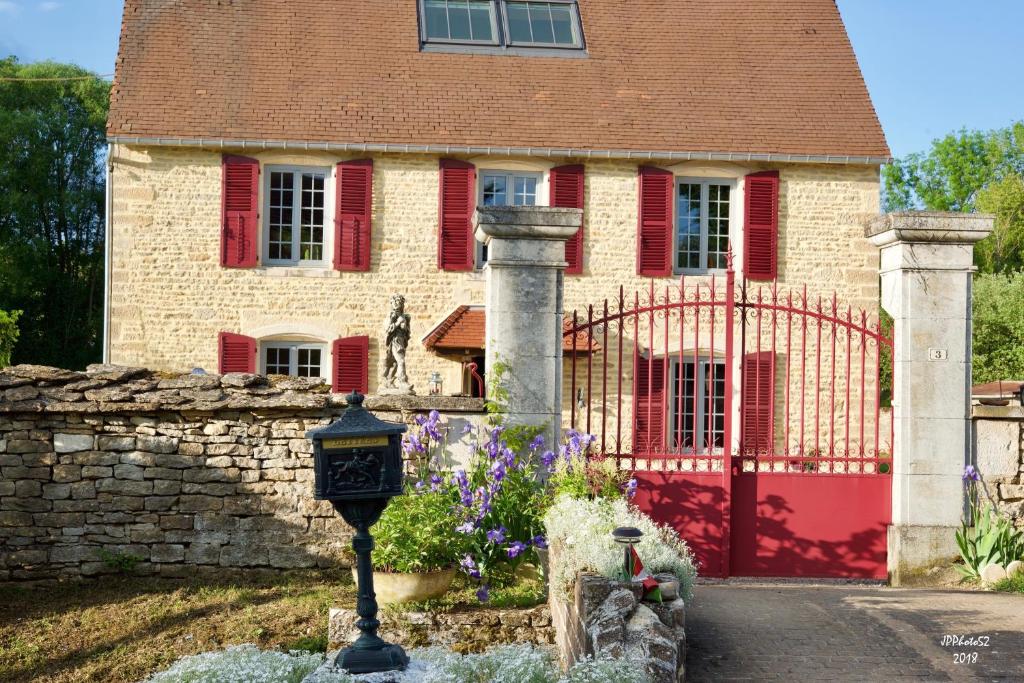 a house with a gate and a clock in front of it at Jungbrunnen Orges in Orges