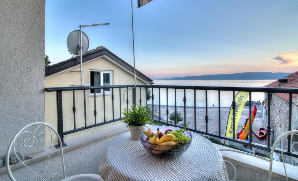 a bowl of fruit on a table on a balcony at Dida moj in Senj