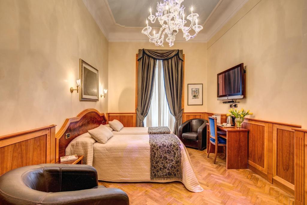 a hotel room with a bed and a chandelier at Relais Conte Di Cavour De Luxe in Rome