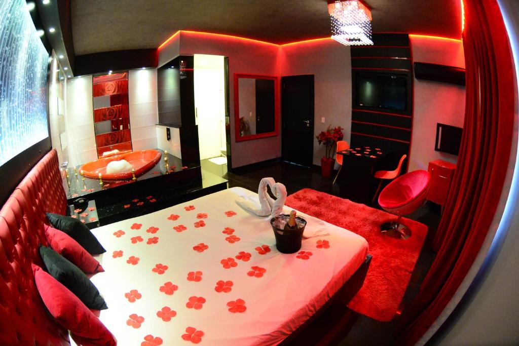 um quarto com uma cama e uma casa de banho com uma banheira em Helus Motel em Passo Fundo