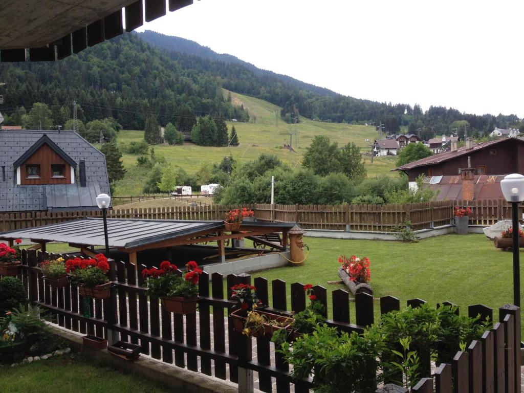 a view of a yard with a fence and flowers at Casa vacanze Rododendro in Tarvisio