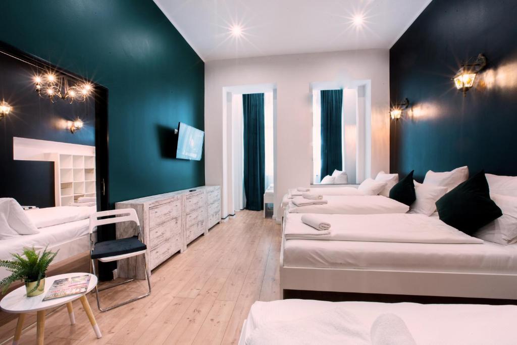 ein Schlafzimmer mit 3 Betten und einer blauen Wand in der Unterkunft Hevals Schloss Appartment in Berlin