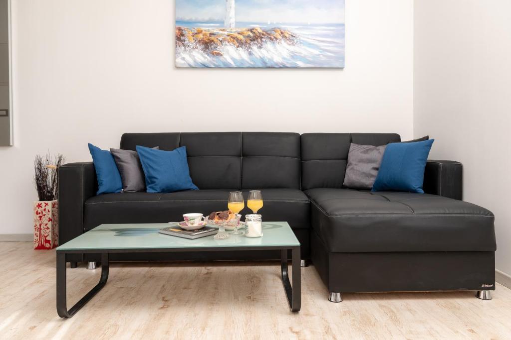 a living room with a black couch and a coffee table at Apartment Linda in Split