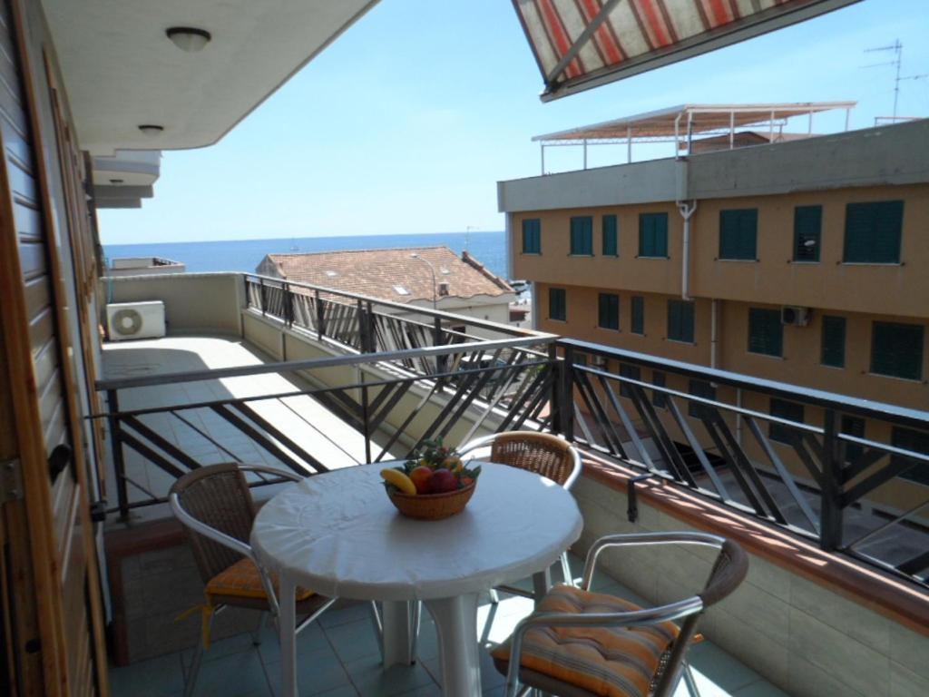 balkon ze stołem i krzesłami oraz widokiem na budynek w obiekcie Casa 1 Sole - Mare - Montagna - con Terrazza panoramica w mieście Riposto