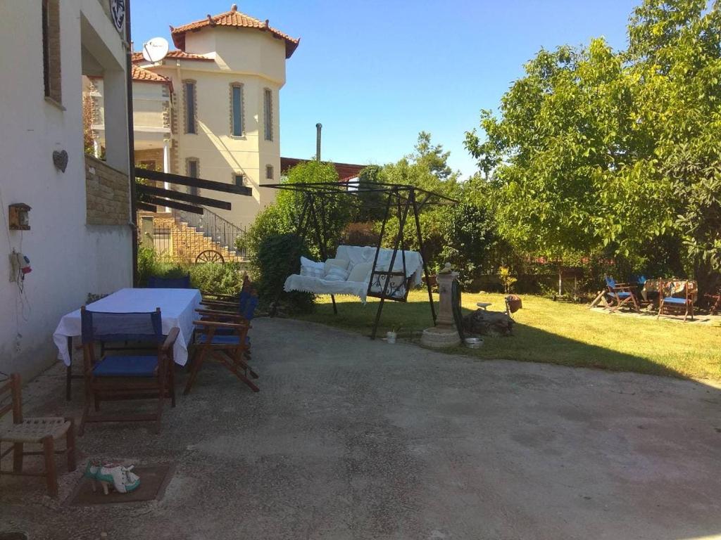 um pátio com uma mesa, cadeiras e um baloiço em Villa with Garden em Perea