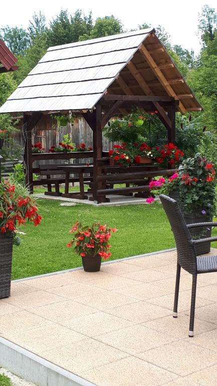 - un kiosque en bois avec un banc et des fleurs dans l'établissement Apartment Perić, à Rastovača