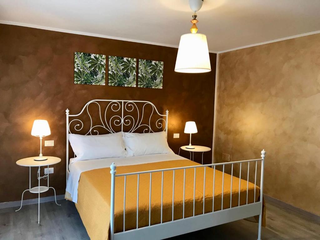 ein Schlafzimmer mit einem Bett mit zwei Tischen und zwei Fenstern in der Unterkunft B&B Red Village in Chieti