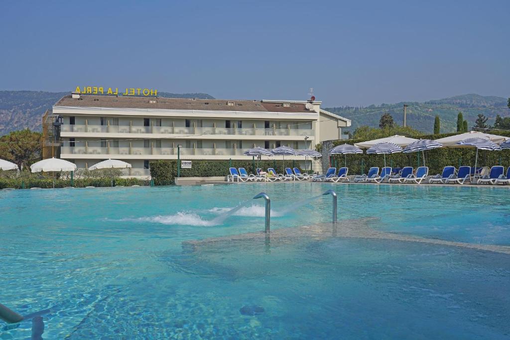 a swimming pool in front of a hotel at Hotel La Perla - Bike Hotel in Garda