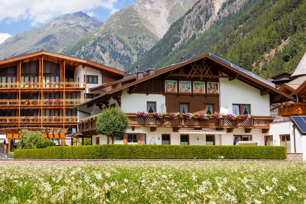 een hotel met bergen op de achtergrond bij Garni Vierjahreszeiten in Sölden
