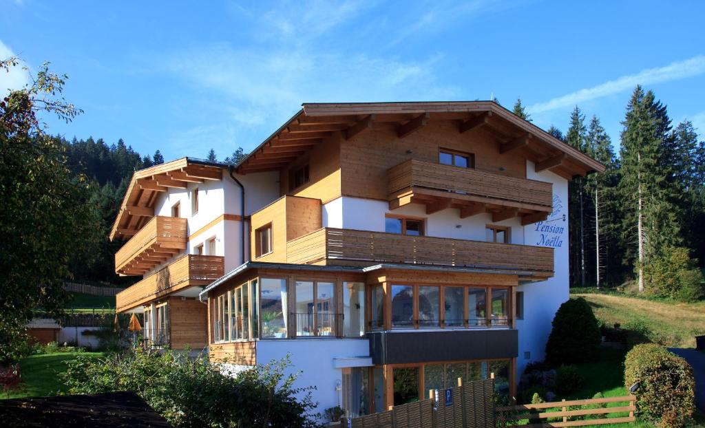 a house with wooden balconies on the side of it at Pension Noella in Sankt Johann in Tirol