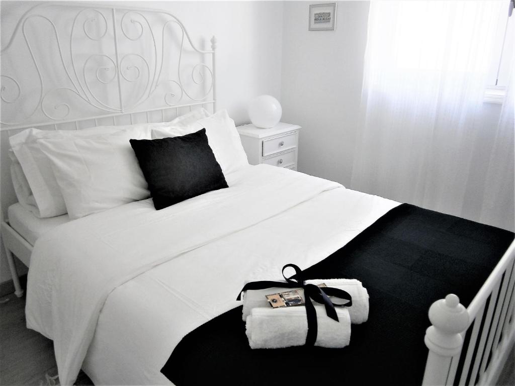 アヴェイロにあるJardim à vistaのベッドルーム1室(白黒の掛け布団付きの白いベッド1台付)