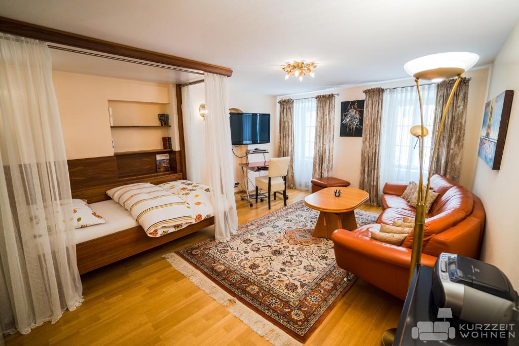 ein Hotelzimmer mit einem Bett und einem Sofa in der Unterkunft Appartements Steingasse in Salzburg