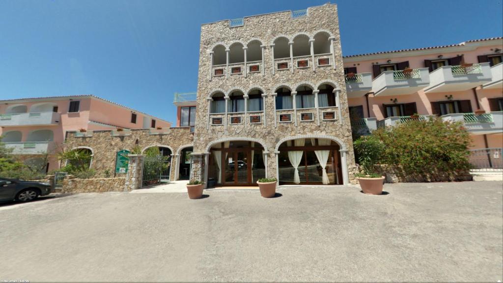 un gran edificio de piedra con macetas delante de él en Residenza Gli Ontani, en Orosei