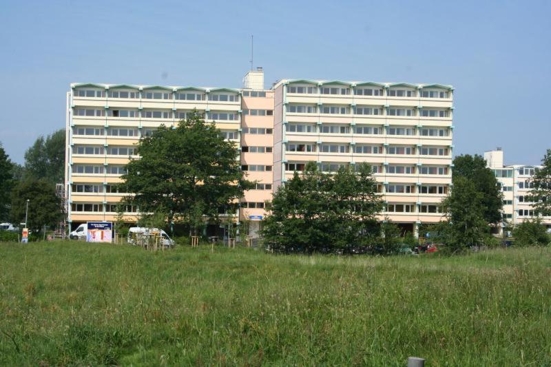 a large building in front of a field of grass at Ferienappartement E417 für 2-4 Personen an der Ostsee in Schönberg in Holstein