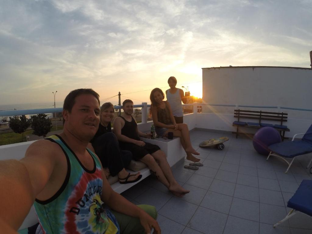 a group of people sitting on top of a roof at Waves Surf Camp Peru in Punta Hermosa
