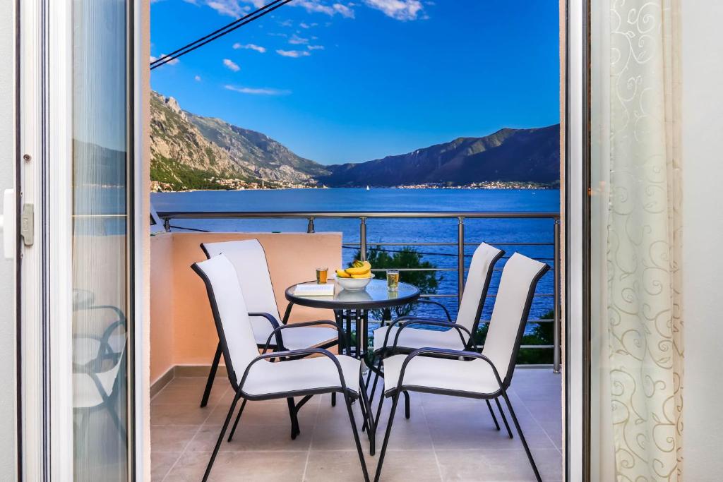 a balcony with a table and chairs and a view of the water at SSM Apartmani in Kotor