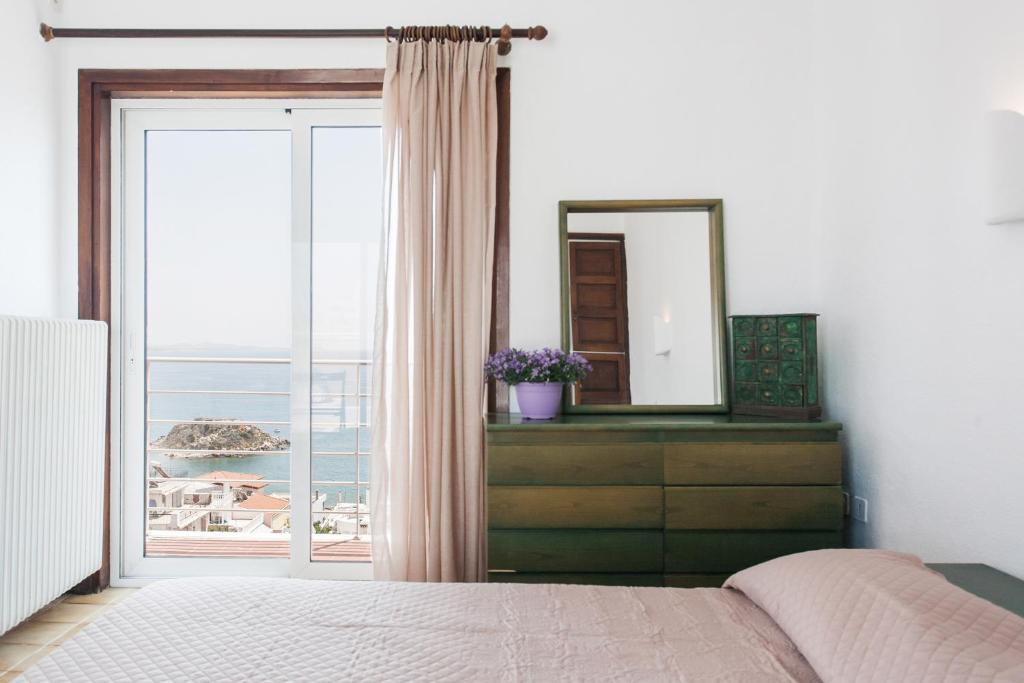 1 dormitorio con cama, espejo y ventana en Holodek Apartments : Kastella en Piraeus