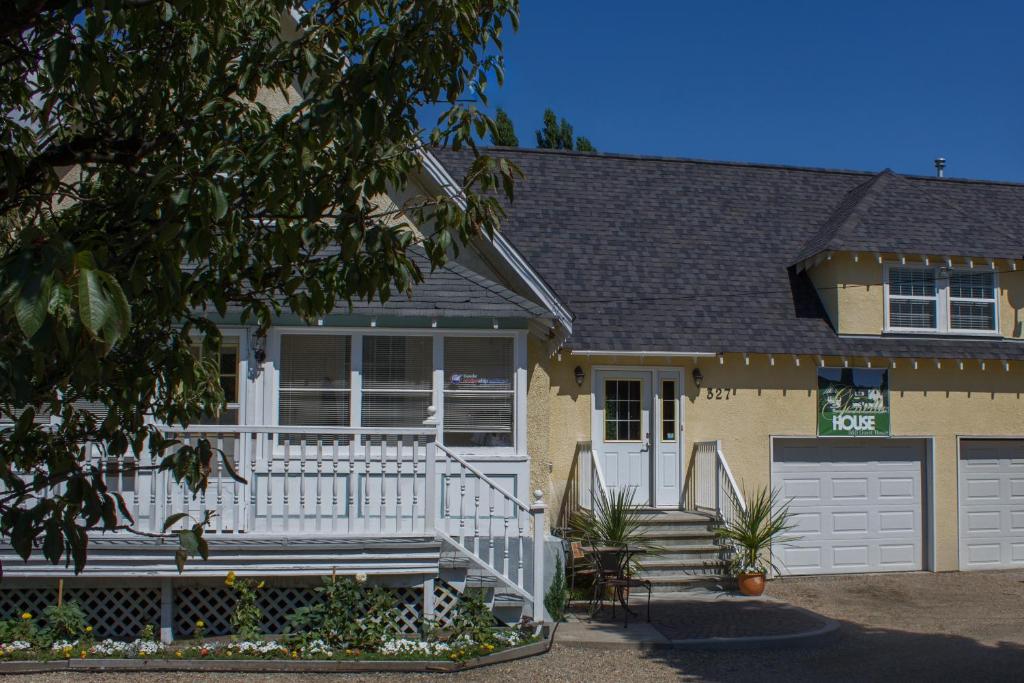 uma casa com um alpendre branco e uma garagem em Genelle House B&B Guest House em Genelle