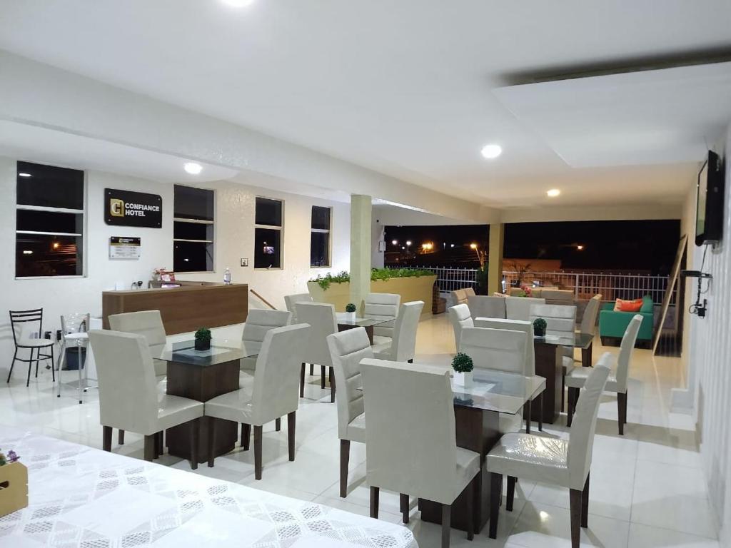 een restaurant met witte stoelen en tafels in een kamer bij Confiance Hotel in Crateús