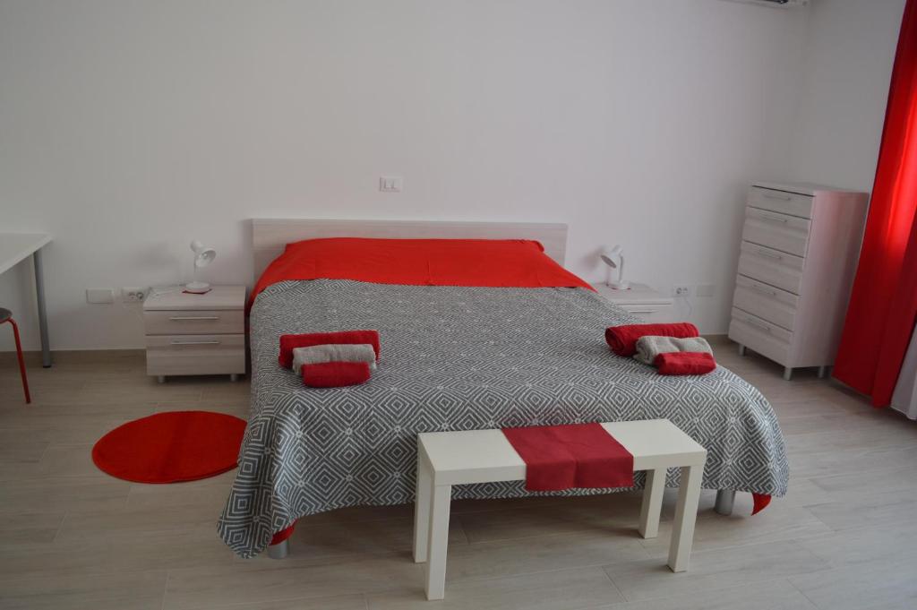 a bedroom with a bed with a red and grey comforter at Margherita's room in Rovinj