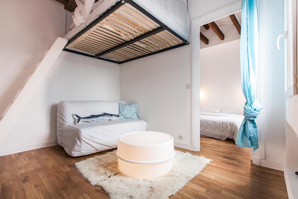 een woonkamer met een bank en een bed bij Charming 30m² border of MONTMARTRE in Parijs