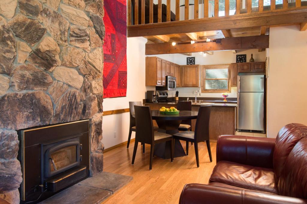 - un salon avec une cheminée et une table avec des chaises dans l'établissement Twining 7, à Taos Ski Valley