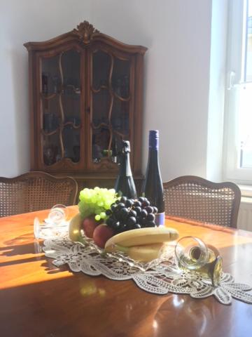 una mesa con una bandeja de frutas y botellas de vino en Marumparkblick, en Bad Sobernheim