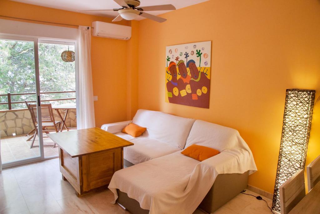sala de estar con sofá y mesa en Apartamento con encanto junto a la playa y en el centro del pueblo, en La Herradura