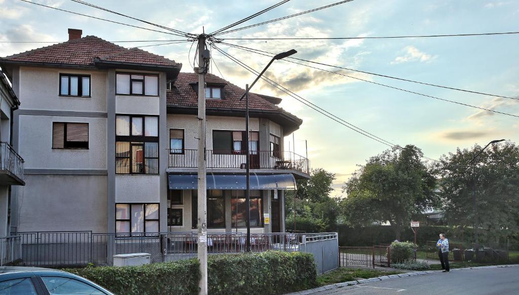 a man is standing in front of a house at Apartmani Malica in Soko Banja