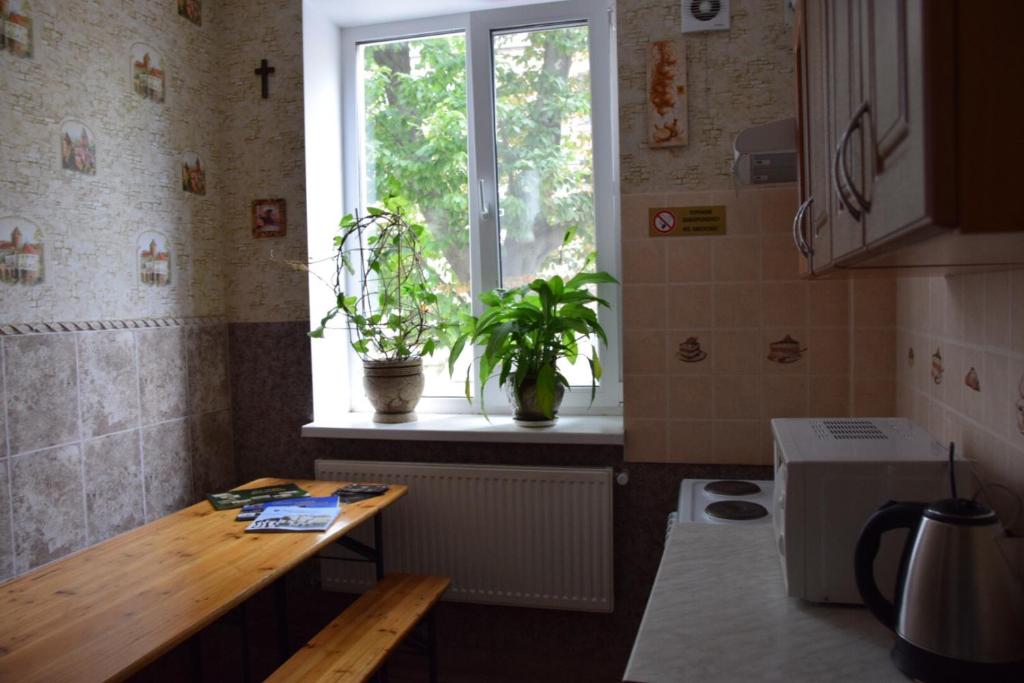 eine Küche mit einem Tisch und einem Fenster in der Unterkunft Hotel Kardinal in Winnyzja