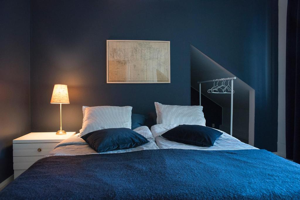 a blue bedroom with a bed with two pillows at Boutique hotel Sawohouse in Kuopio