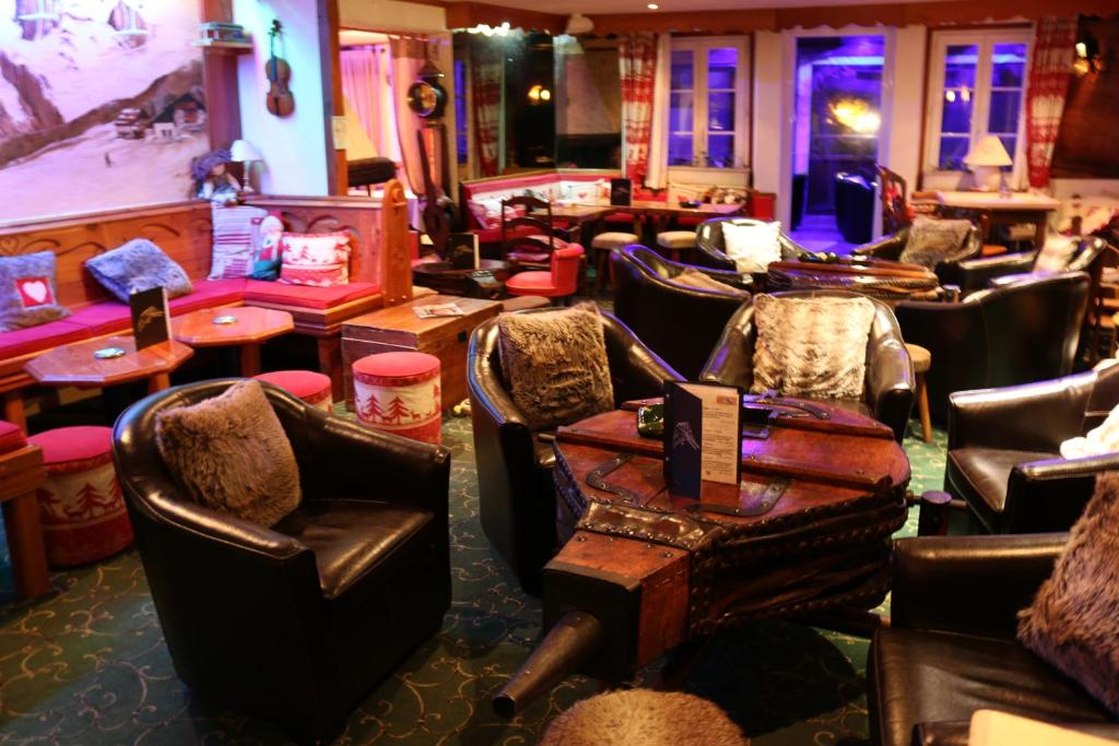 a bar with leather chairs and tables in a room at Logis Hôtel et Spa Le Christiania in La Salle-les-Alpes