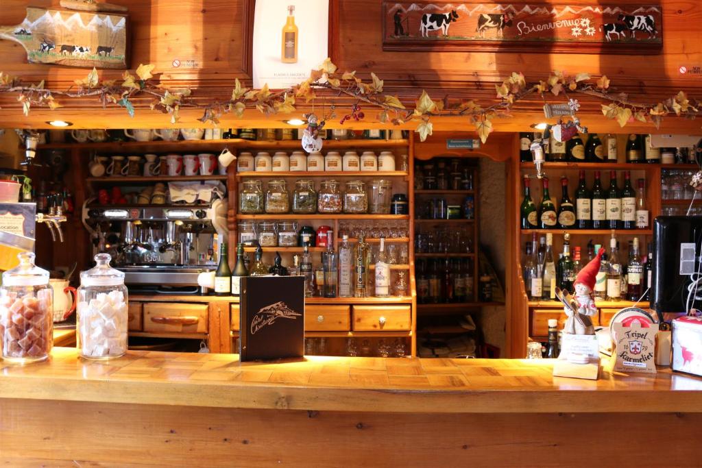 a bar with a lot of bottles of alcohol at Logis Hôtel et Spa Le Christiania in La Salle-les-Alpes