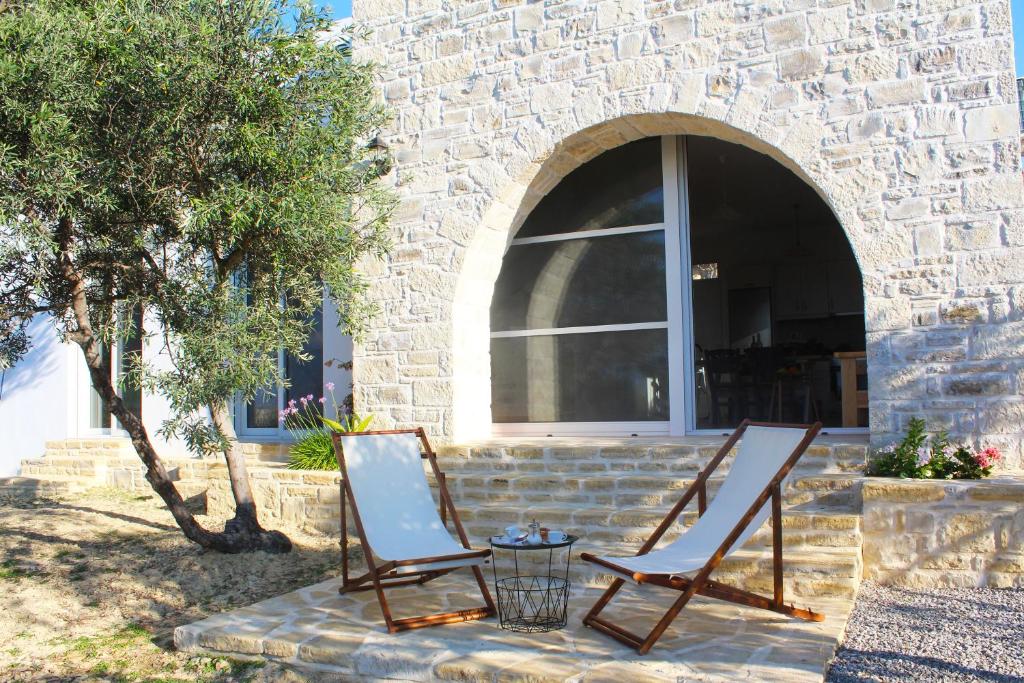 deux chaises et une table devant un bâtiment dans l'établissement Villa Marikami, à Kamilárion